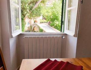 een kamer met een raam en een tafel met een rode handdoek bij Casetta al Ponte Subiaco in Subiaco