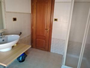 baño con lavabo y puerta de madera en B&B I lupi, en Casa Furno