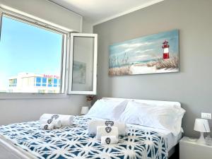 a bedroom with a bed and a window with a lighthouse at Beach Front Apartment Sabbiadoro in Lignano Sabbiadoro