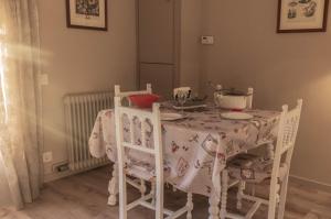 uma mesa de jantar com cadeiras e uma toalha de mesa branca em Vistas espectaculares en el centro de Puigcerdà em Puigcerdà