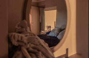 espejo que refleja un dormitorio con cama en una habitación en Vistas espectaculares en el centro de Puigcerdà en Puigcerdá