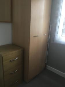 a room with a closet with a refrigerator and a window at Tamaras Place in Leysdown-on-Sea