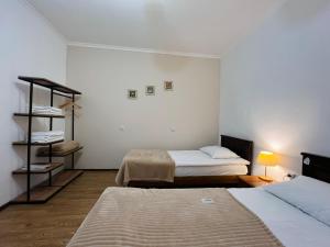 a small room with two beds and a shelf at Meshia Apartment in Kazbegi