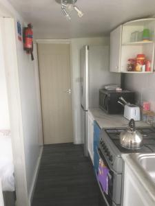 una pequeña cocina con fogones y fregadero en Tamaras Place en Leysdown-on-Sea