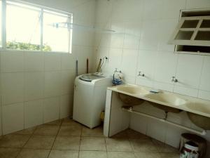 a bathroom with a sink and a washing machine at Apartamento Inconfidência Diamantina in Diamantina