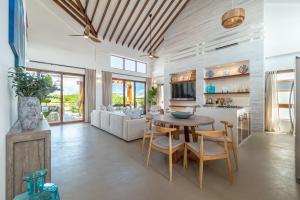 a kitchen and living room with a table and chairs at Casa Brisa & The PoolClub at Mahogany Bay! in San Pedro