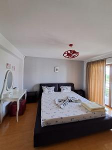 a bedroom with a bed and a table and a mirror at Casa verde 2 in Pantelimon