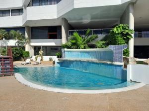 a swimming pool in front of a building at Executive Style Condo With Sea Views in Porlamar