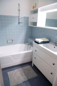 ein Badezimmer mit einer weißen Badewanne und einem Waschbecken in der Unterkunft Appartement Arcachon en 1ère ligne face à la mer in Arcachon