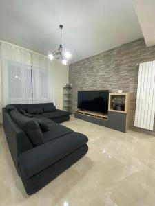 sala de estar con sofá negro y TV en B&B IL PALCOSCENICO, en Salerno