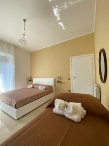 1 dormitorio con 2 camas y toallas en el suelo en B&B IL PALCOSCENICO, en Salerno