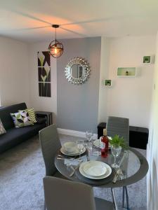a dining table and chairs in a living room at NEC/Airport - The Allium, Two bedroom apartment in Marston Green