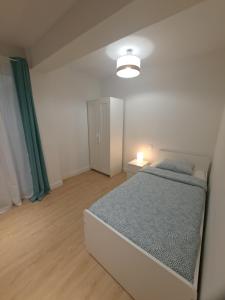 a white bedroom with a bed and a lamp at VISTAS MURALLA CENTRICO EN ZONA PEATONAL Wi-fi VUT LU 3270 in Lugo