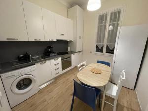 a kitchen with a table and a sink and a washing machine at 2 pièces BeHappy next Monaco in Roquebrune-Cap-Martin