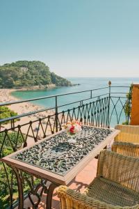a table on a balcony with a view of a beach at Rigat Park & Spa Hotel - Adults Recommended in Lloret de Mar