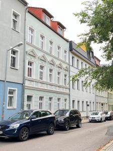 two cars parked on a street in front of buildings at Altstadtjuwel am Hospitalplatz - 3 Zimmer mit Balkon in Erfurt