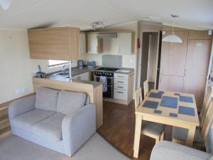 una cucina con divano e tavolo in una camera di Kingfisher Bordeaux 8 Berth Central Heated FREE WIFI a Ingoldmells