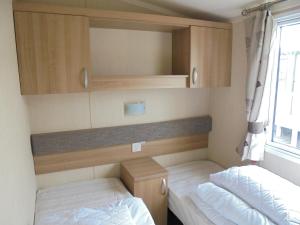 a small room with two beds and a window at Kingfisher Bordeaux 8 Berth Central Heated FREE WIFI in Ingoldmells