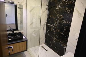 bagno con doccia in vetro e lavandino di La Ruota Hotel Sharr a Dragash