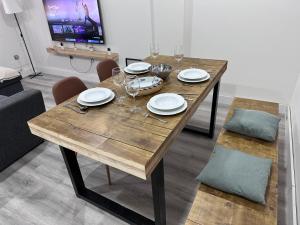 Una mesa de madera con platos y copas de vino encima. en Casa Libertad Estepona, en Estepona