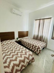 sypialnia z 2 łóżkami i oknem w obiekcie Departamentos Villa 112 w mieście Mazatlán