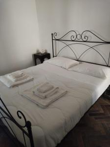 un letto bianco con lenzuola e asciugamani bianchi di Domus Al.Me a Castelmezzano