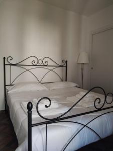 una camera da letto con un grande letto bianco con struttura metallica di Domus Al.Me a Castelmezzano