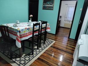 uma mesa com cadeiras e uma toalha de mesa em Casa inxalmel em Blumenau