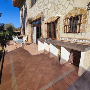 un patio avec une table et un bâtiment en pierre dans l'établissement Casa Rural Sierra de las Nieves 2, à Tolox