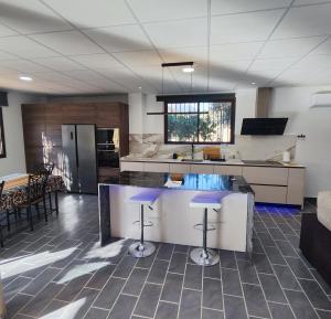 une cuisine avec un comptoir et quelques tabourets de bar dans l'établissement Casa Rural Sierra de las Nieves 2, à Tolox