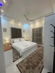 a bedroom with a white bed and a rug at Apartment in Bayt Al Jabal شقة في بيت الجبل in Sayq