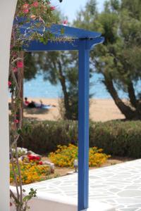 a blue stand in a garden with flowers at Paros Inn in Logaras
