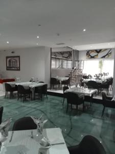 uma sala de jantar com mesas e cadeiras num restaurante em Hotel Embaixador em Beira