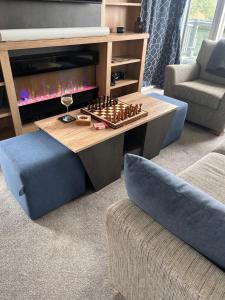 a living room with a chessboard on a table and two chairs at Hotchkin Lodge in Woodhall Spa