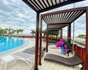 Sensacional apartamento en Samaria Club de Playa في سانتا مارتا: شرفة مع كراسي ومسبح