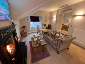 a living room with a couch and a fireplace at Windermere Boutique Hotel Spa Suites & Hot Tubs in Windermere