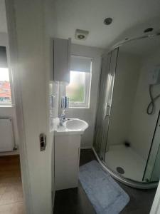 a white bathroom with a shower and a sink at Solihull house weekly/ monthly in Sheldon