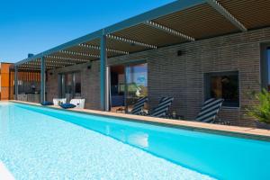 a swimming pool in front of a house at Casa Arbor Blanco with a see view and heated infinity pool in Fažana