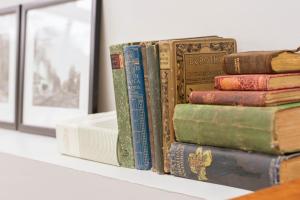 a stack of books sitting on a shelf at Rozenburg Guest House in Stellenbosch