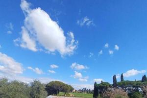un ciel bleu avec des nuages et des arbres dans un champ dans l'établissement Appia Antica Rooms, à Rome