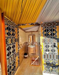 a bathroom with a bunch of wine bottles on the wall at MARS lUXURY CAMP WADI RUM in Wadi Rum