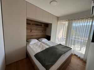 un letto in una camera con una grande finestra di Apartment Deluxe Ossiacher See - Gerlitzen a Sattendorf