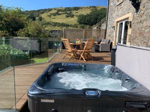 een hot tub op een terras met een tafel en stoelen bij The Carthouse (Luxury 2 bed with private hot tub) in Newburgh