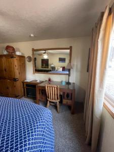 a bedroom with a bed and a desk and a mirror at Stewart Chalet @ Yosemite/Bass Lake in Bass Lake