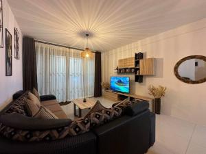 SeaSand-Entire Luxury 3 BD condo - Close to beach في فليك-إن-فلاك: غرفة معيشة مع أريكة وتلفزيون
