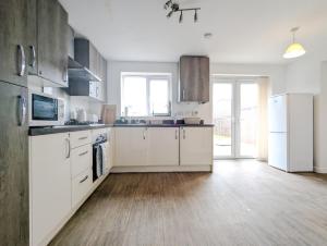 a kitchen with white appliances and a wooden floor at Guest Rooms Near City Centre & Anfield Free Parki in Liverpool