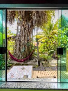 - une fenêtre donnant sur un jardin avec un hamac dans l'établissement Barra Quintal - Studio 2, à Barra Grande