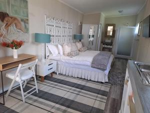 a bedroom with a bed and a desk and a sink at Milky Way in Hermanus