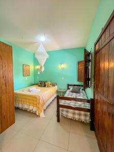 1 dormitorio con 2 camas y paredes verdes en Barra Quintal - Studio 2, en Barra Grande