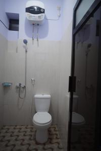 W łazience znajduje się biała toaleta i prysznic. w obiekcie OYO 93159 Homestay Sehat w mieście Gresik